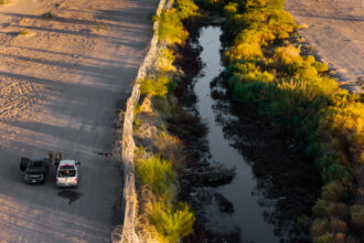 In El Paso, the Rio Grande, with concertina wire and law enforcement along the U.S. side of the border. Credit: Brandon Bell/Getty Images