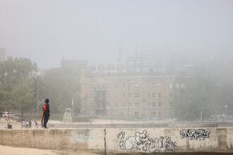 A lifeguard stands watch amid a haze of Canadian wildfire smoke at Loyola Beach on Chicago’s North Side in June. The West and South sides of the city get heavy air pollution all year. Credit: Anthony Vazquez/Sun-Times