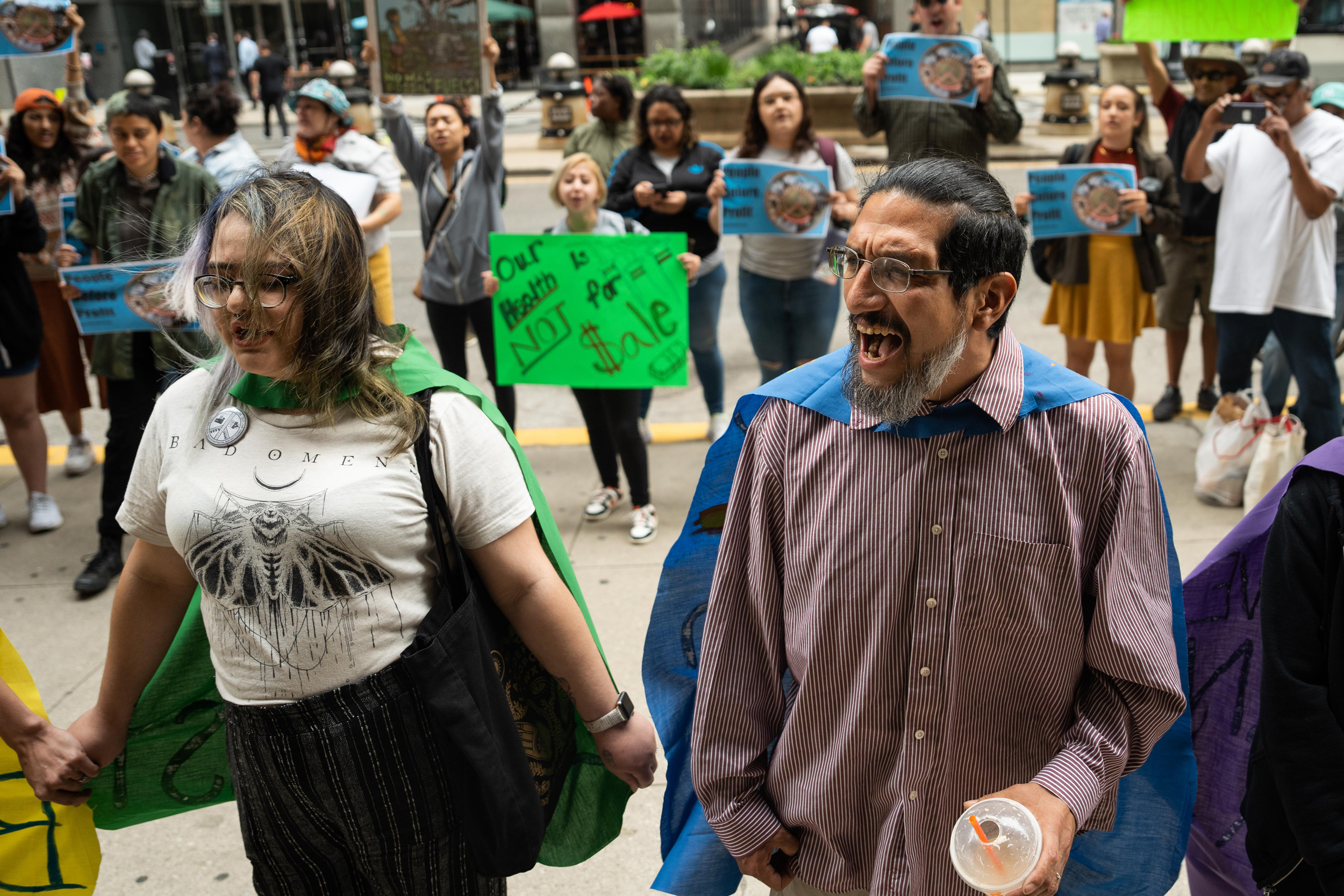 Samuel Corona (right), an activist with the Alliance of the Southeast, chants, “Stop General Iron” outside Chicago’s City Hall. The U.S. Department of Housing and Urban Development says it will no longer monitor a civil rights agreement with Chicago over the controversial scrap metal operation. Credit: Pat Nabong/Sun-Times