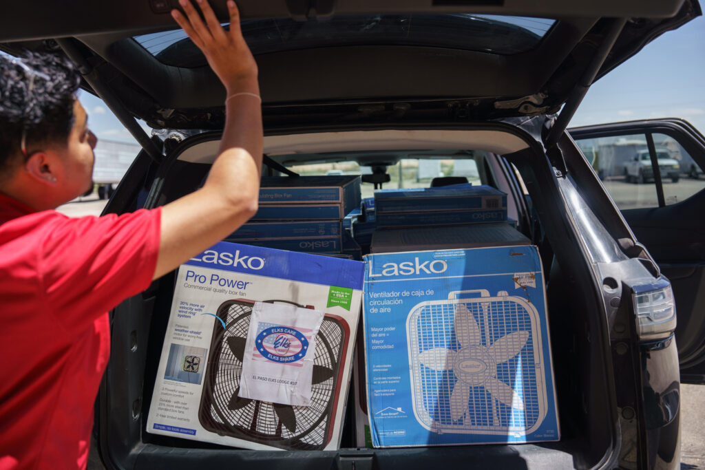 Kevin Murillo, with RUA insurance company, closes the hatch on his vehicle after picking up fans he is distributing to the elderly through a program run by the Texas Extreme Weather Task Force in El Paso.
