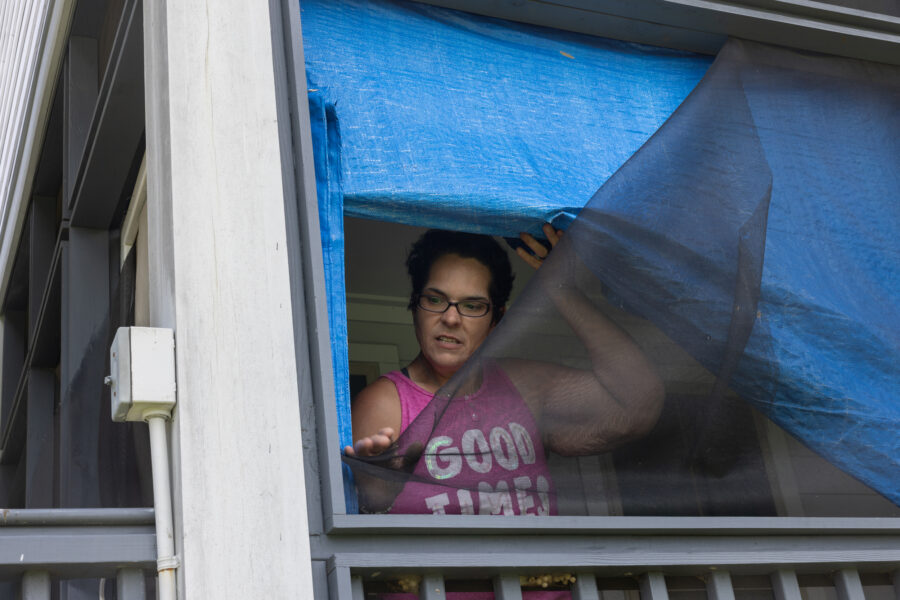Kristi Naquin shows wind damaged screens at her home, built as part of the first federally funded relocation project in the United States. Naquin was among the more than 30 residents who used to live along the Louisiana coastline at Isle de Jean Charles, a mostly Indigenous community. Naquin says the 3-year-old homes are substandard. Credit: Jeffrey Basinger/Floodlight