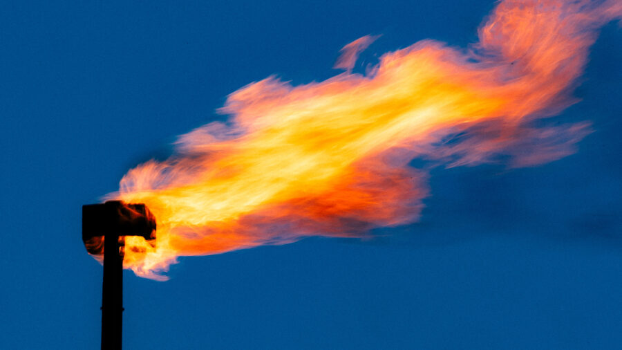 A blackened pipe with a large gout of flame swirling out of the top.