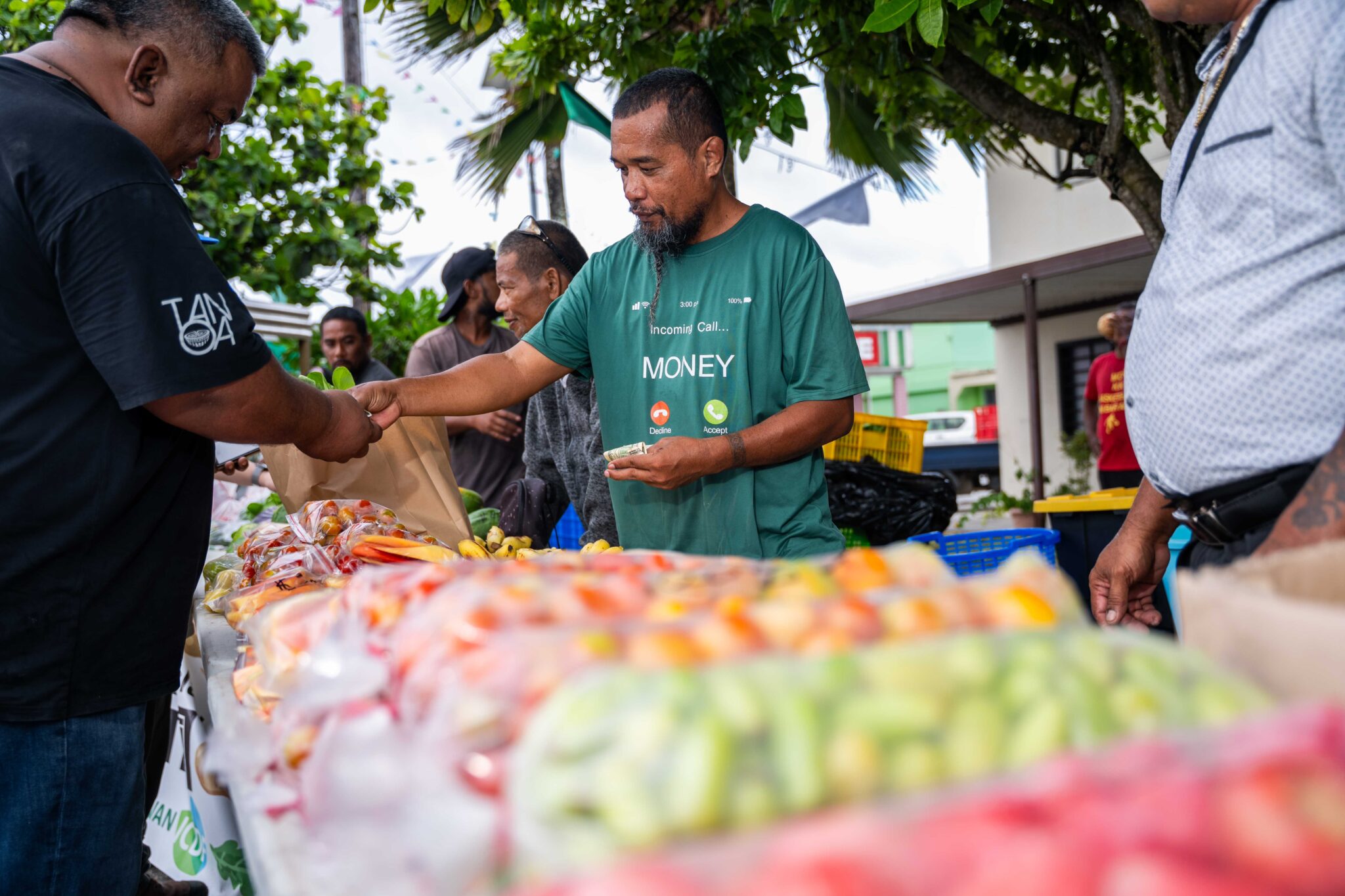 Foster Manwe, a farmer from Laura on Majuro Atoll, sells his produce at a farmers market set up to celebrate the 75th anniversary of Robert Reimers Enterprises, an important business for the nation of islands and atolls. Credit: Chewy Lin/Civil Beat