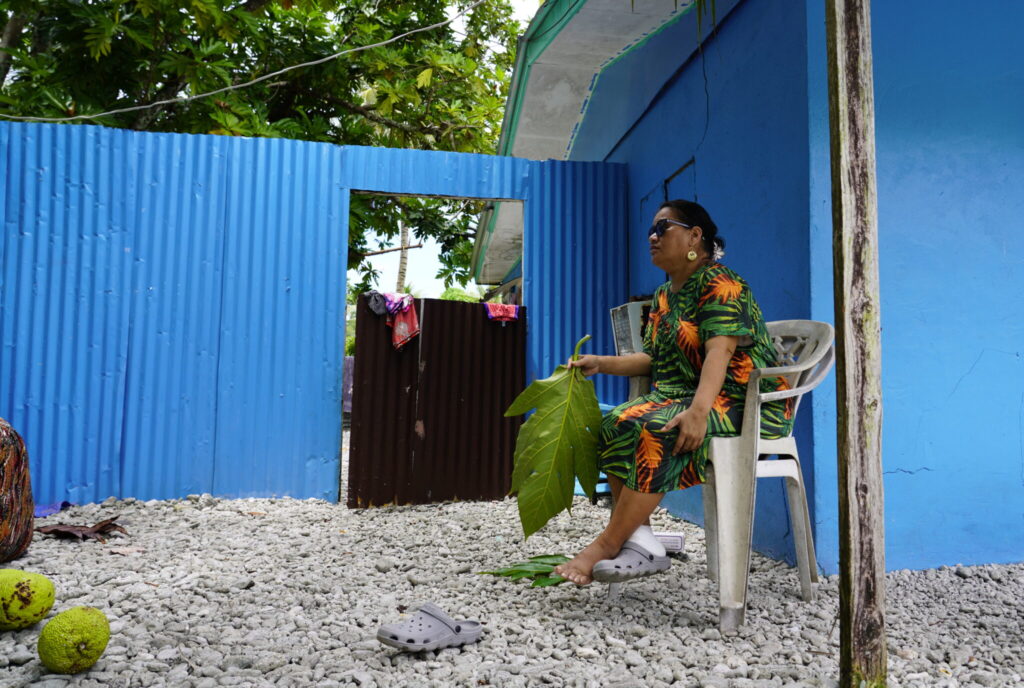 Angelina Mathusla, nursing a sprained ankle, watches as community members help her preserve breadfruit, a process she particularly values because she doesn’t like seeing her fruit wasted. Credit: Thomas Heaton/Civil Beat