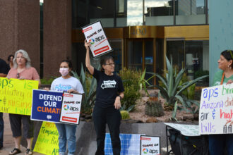 Sandy Bahr (center), the Sierra Club’s Grand Canyon chapter director, speaks during a protest on Thursday over Arizona Power Service’s recent decision to walk back its clean energy goals. Credit: Wyatt Myskow/Inside Climate News