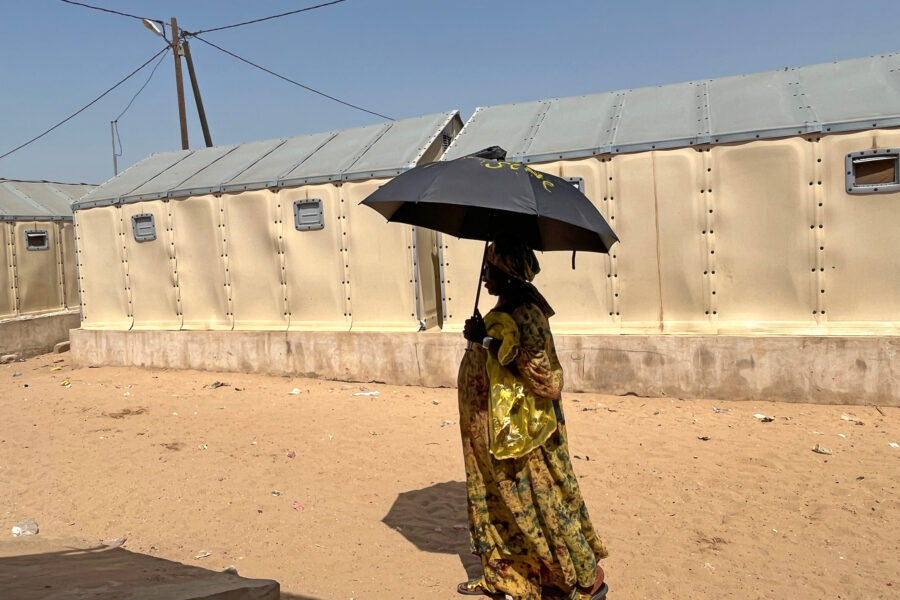 A fishing vendor uses an umbrella to protect herself from the midday sun during a heat wave in St. Louis, Senegal. Credit: Lucia Weiß/picture alliance via Getty Images