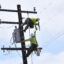 Southern California Edison technicians attach power lines to a utility pole on July 13 in Culver City, Calif. Credit: Chris Delmas/AFP via Getty Images