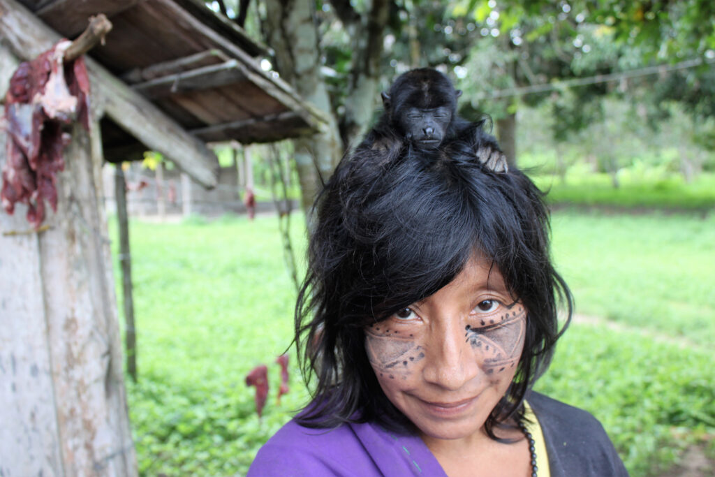 A monkey sits on a woman’s head in the Awa Guaja Indigenous Community of the Caru Indigenous Land in Brazil. Credit: Paula Prist