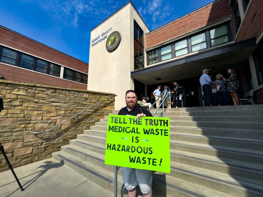 A Remlap, Alabama, resident holds a sign outside the Blount County Courthouse on Thursday following a contentious meeting. Credit: Lee Hedgepeth/Inside Climate News