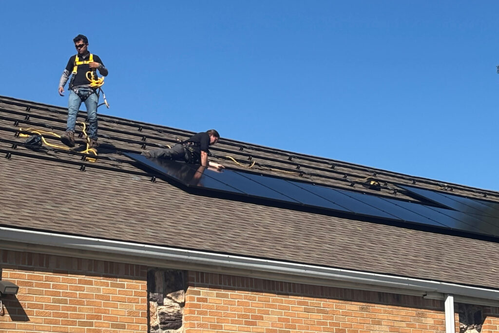 Workers install solar panels on the roof of the New Mount Hermon Missionary Baptist Church. Credit: Courtesy of Michigan Interfaith Power & Light