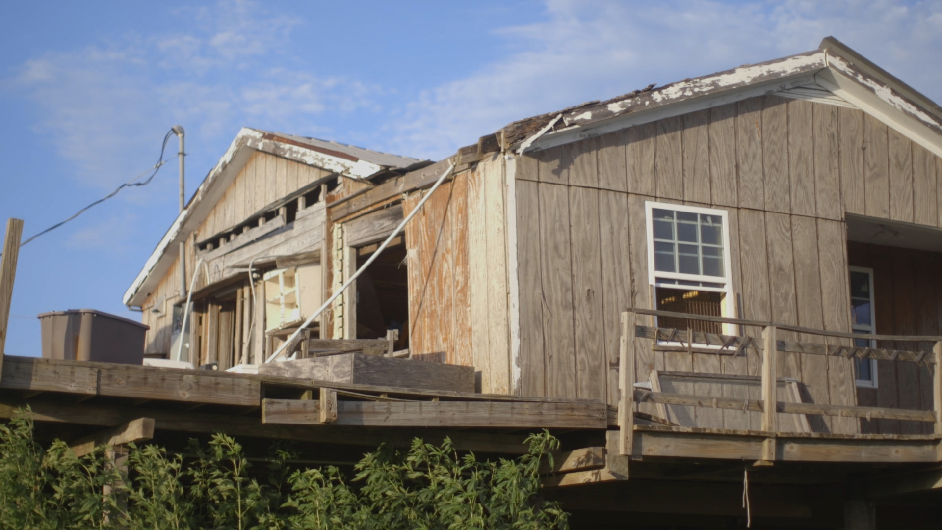Chris Brunet visits his former home, left, on Isle de Jean Charles. La. Despite his ancestral ties to the Island, hurricanes and coastal erosion ultimately forced him to relocate to higher ground. Credit: Evan Simon/Floodlight