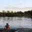 A Wayana Indigenous man sits on the embankment of the Maroni River in Southern French Guiana. Credit: Benoit Virginie