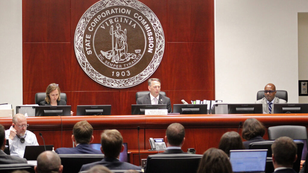 State Corporation Commissioner Chairman Sam Towell (center) speaks at the opening of Dominion’s biennial rate case, with judges Kelsey Bagot (left) and Jehmal Hudson. Credit: Charles Paullin/Inside Climate News