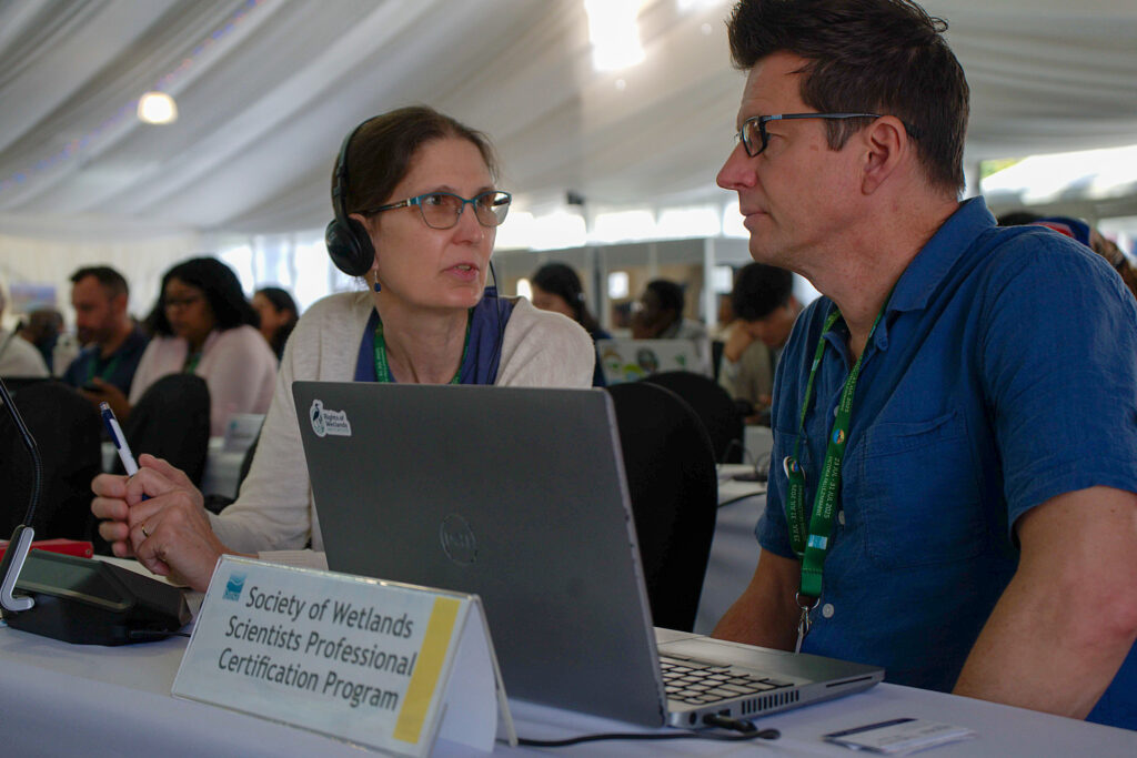 Gillian Davies and Matthew Simpson talk during the 15th Conference of the Parties to the Ramsar Convention on Wetlands in Victoria Falls, Zimbabwe, on July 30. Credit: Katie Surma/Inside Climate News