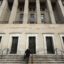 The Interior Department headquarters is shown from an angle with a person walking up the steps