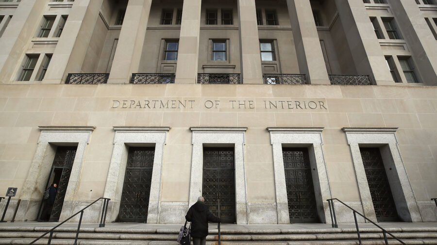 The Interior Department headquarters is shown from an angle with a person walking up the steps