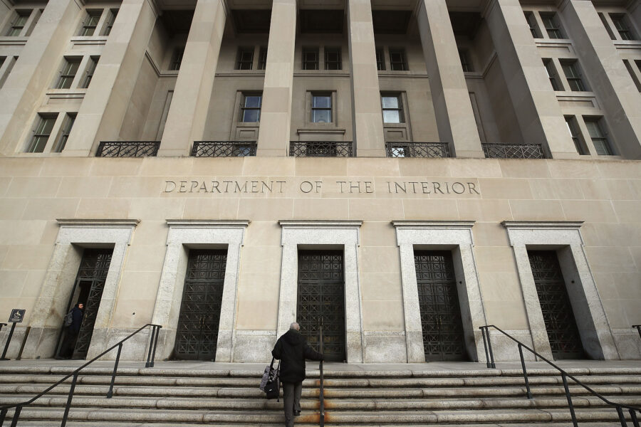 The Interior Department headquarters is shown from an angle with a person walking up the steps