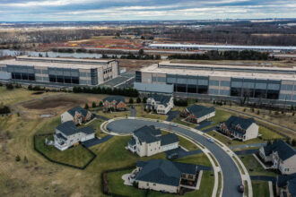 Amazon data centers loom over houses at the edge of a neighborhood in Loudoun County, Va. Credit: Jahi Chikwendiu/The Washington Post via Getty Images