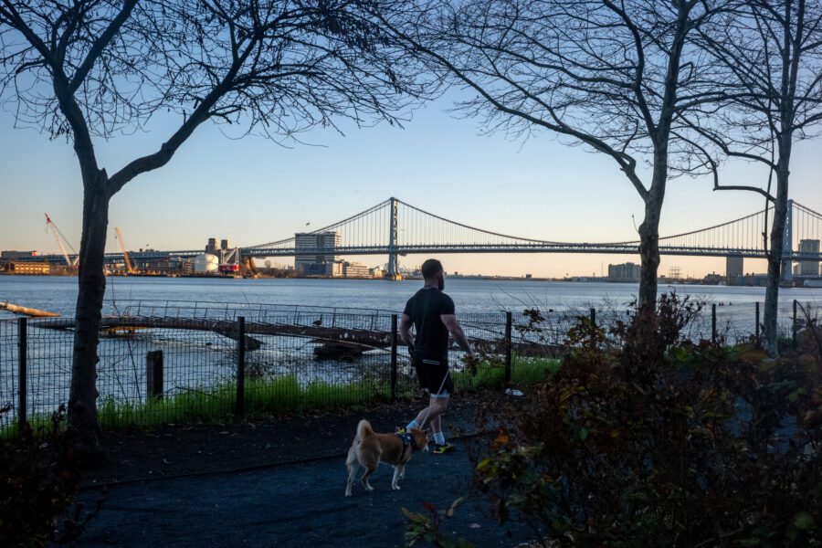 A person walks their doing along the Delaware River in Philadelphia. Credit: Thomas Hengge/Anadolu Agency via Getty Images