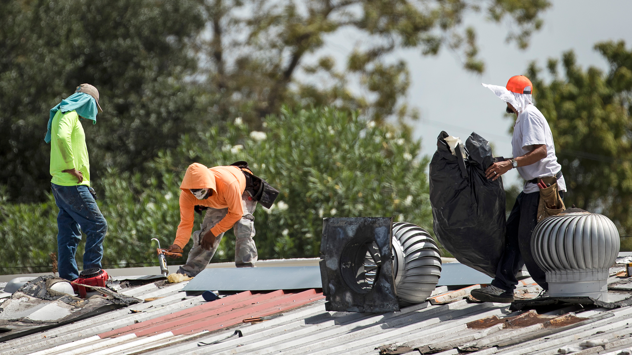 Roofers repair a metal roof during a heat wave in Houston on Sept. 1, 2020. Credit: Brett Coomer/Houston Chronicle via Getty Images