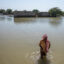 A man wades through floodwater on Oct. 18, 2022, in Johi, Pakistan. Nearly one-third of Pakistan was deeply affected by flooding which hit the country in 2022. Credit: Getty Images