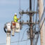 A Central Maine Power lineworker repairs a transmission line in Portland, Maine. Credit: Brianna Soukup/Portland Press Herald via Getty Images
