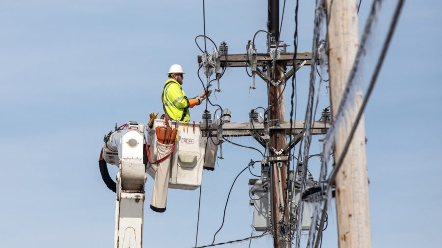 A Central Maine Power lineworker repairs a transmission line in Portland, Maine. Credit: Brianna Soukup/Portland Press Herald via Getty Images