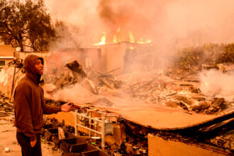A man views his property as it burns during the Eaton Fire in the Altadena area of Los Angeles County on Jan. 8. Credit: Josh Edelson/AFP via Getty Images