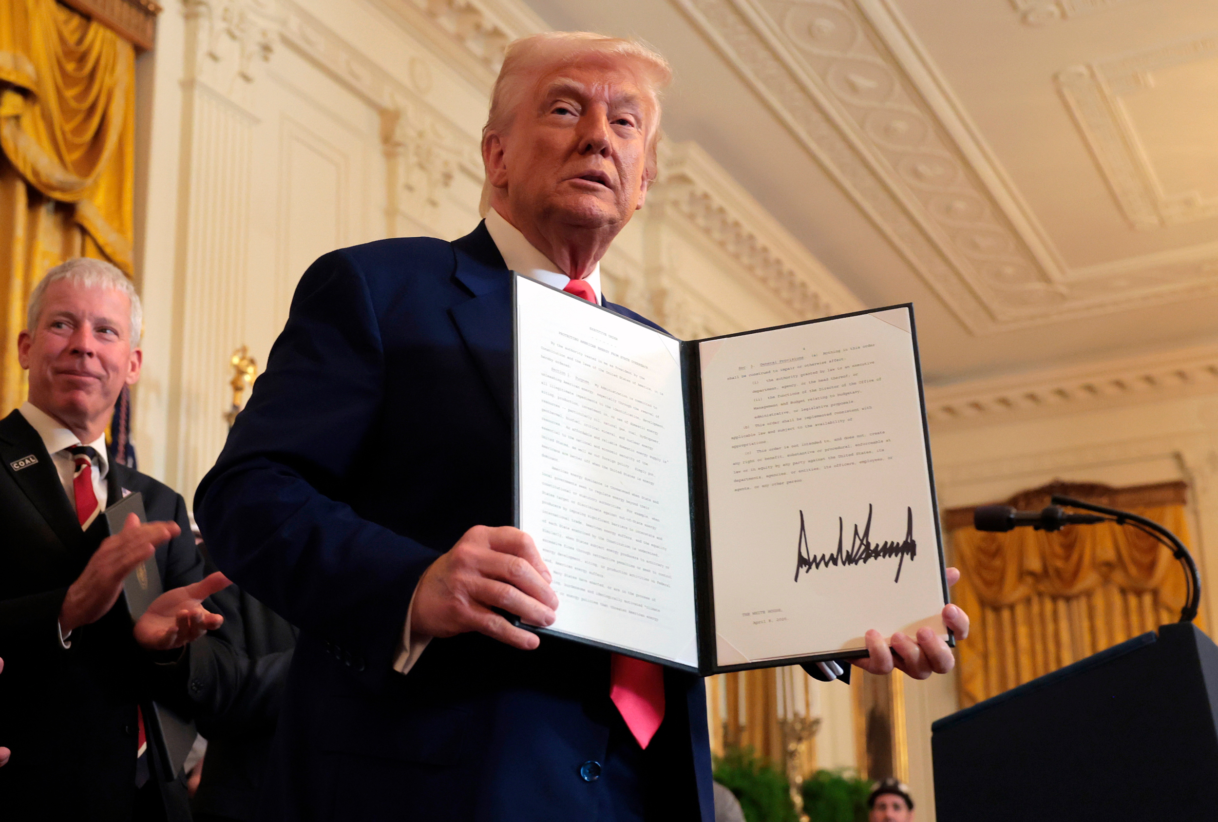 President Donald Trump,  joined by Energy Secretary Chris Wright, holds an executive order on energy production during a ceremony at the White House on April 8. Credit: Anna Moneymaker/Getty Images