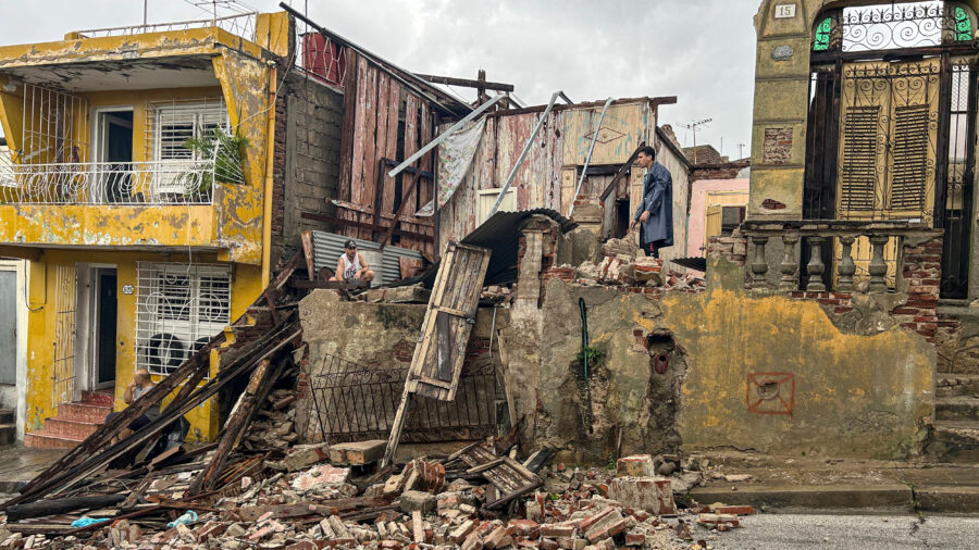 People salvage belongings from the rubble of their home on Wednesday after it collapsed during Hurricane Melissa’s passage through Santiago de Cuba. Credit: Yamil Lage/AFP via Getty Images