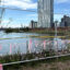 A view from a new area of Brooklyn’s Bushwick Inlet Park. Across the inlet, the brown MTA facility marks where property firm Gotham Organization wants to build apartments. Credit: Lauren Dalban/Inside Climate News