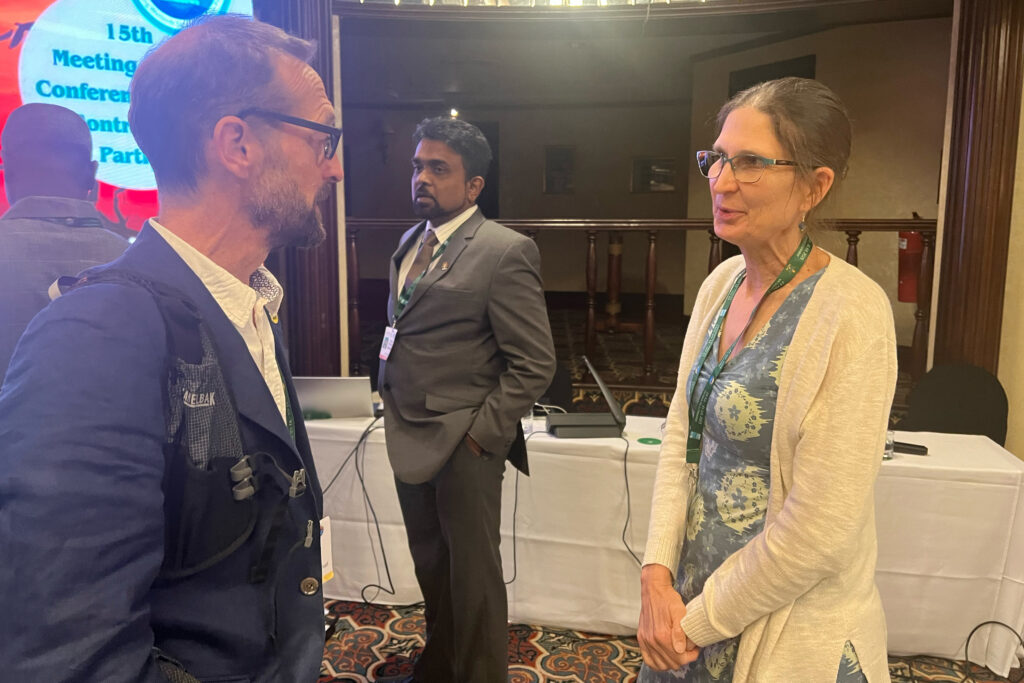 Gillian Davies speaks with a colleague after presenting at a rights of wetlands side event at the 15th Conference of the Parties to the Ramsar Convention on Wetlands in Victoria Falls, Zimbabwe, on July 28. Credit: Katie Surma/Inside Climate News