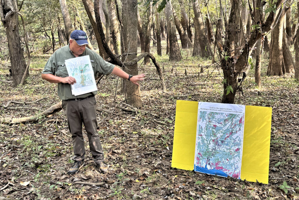 Keith Tassin, deputy state director for The Nature Conservancy in Alabama, shows a map of the preserve and how it fits into the larger vision of creating connected natural areas from the Gulf of Mexico to the foothills of the Appalachian Mountains. Credit: Dennis Pillion/Inside Climate News