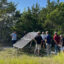 Paul Westbrook shows a solar panel placed at the edge of his Fairview, Texas, property, to a tour group gathered for Sun Day — a day meant to commemorate the power of clean energy. Credit: Arcelia Martin/Inside Climate News