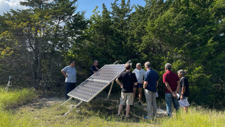 Paul Westbrook shows a solar panel placed at the edge of his Fairview, Texas, property, to a tour group gathered for Sun Day — a day meant to commemorate the power of clean energy. Credit: Arcelia Martin/Inside Climate News