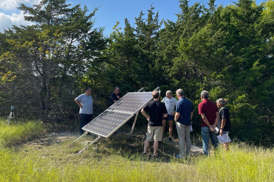 Paul Westbrook shows a solar panel placed at the edge of his Fairview, Texas, property, to a tour group gathered for Sun Day — a day meant to commemorate the power of clean energy. Credit: Arcelia Martin/Inside Climate News