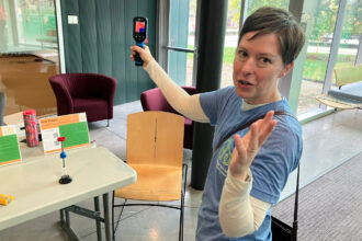 Rachel Kutzley demonstrates a thermal camera, a device that can help to identify the leakage of heat, at the Energy Smart Home Expo in Columbus, Ohio, on Oct. 25. Credit: Dan Gearino/Inside Climate News