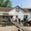 Water pools in the front yard of a house in “The Hole” of New York City. A makeshift bridge has been constructed out of wooden planks. Credit: Lauren Dalban/Inside Climate News