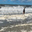 People wade through PFAS-contaminated sea foam at North Carolina’s Holden Beach in October 2022. Credit: Clean Cape Fear