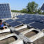 Workers remove solar panels from an industrial building. Credit: Waltraud Grubitzsch/picture alliance via Getty Images