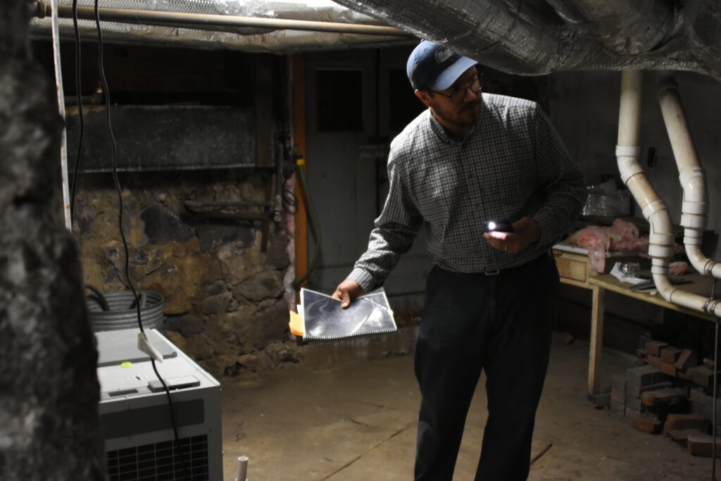 Paul Wright explaining dehumidification efforts in the base of the House of the Seven Gables. Credit: Ryan Krugman