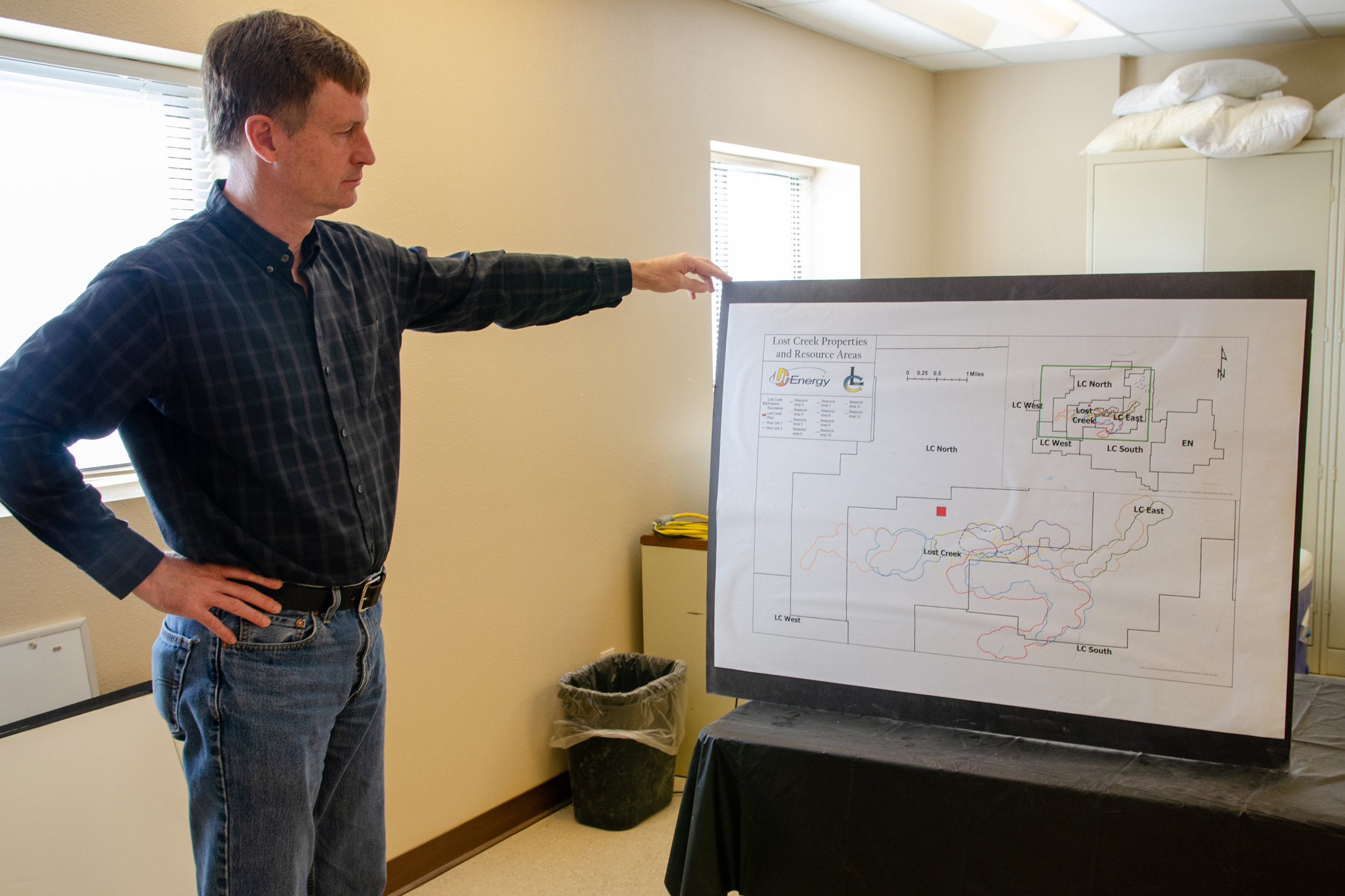John Cash holds a map of UR Energy’s Lost Creek production facility, permitted to extract 1.2 million tons of uranium. Credit: Jake Bolster/Inside Climate News