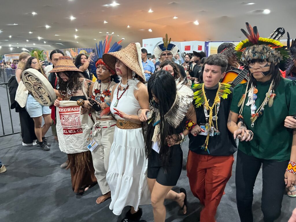 Indigenous climate activists marched on Friday through the conference hall at COP30 in Belem, Brazil, to  protest continued fossil fuel exploitation on Indigenous lands. Credit: Bob Berwyn/Inside Climate News  