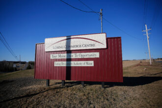Transmission lines stand above the entrance to the Loring Commerce Centre at the site of the former Loring Air Force Base. Credit: Derek Davis/Portland Portland Press Herald via Getty Images