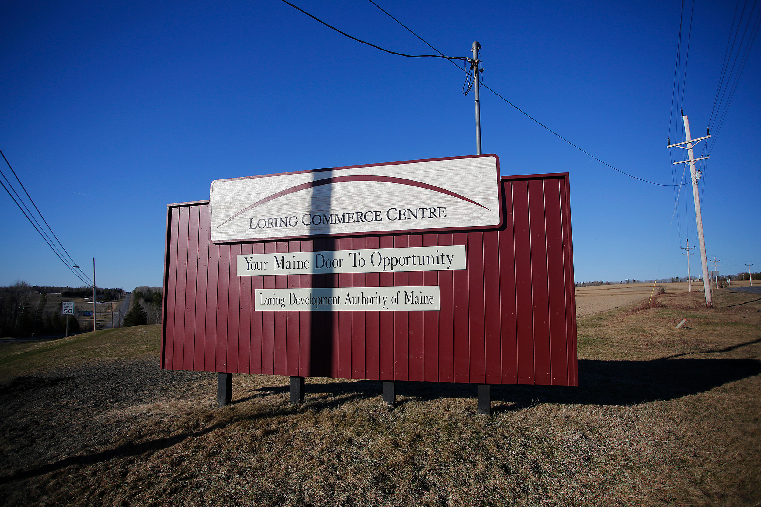 Transmission lines stand above the entrance to the Loring Commerce Centre at the site of the former Loring Air Force Base. Credit: Derek Davis/Portland Portland Press Herald via Getty Images