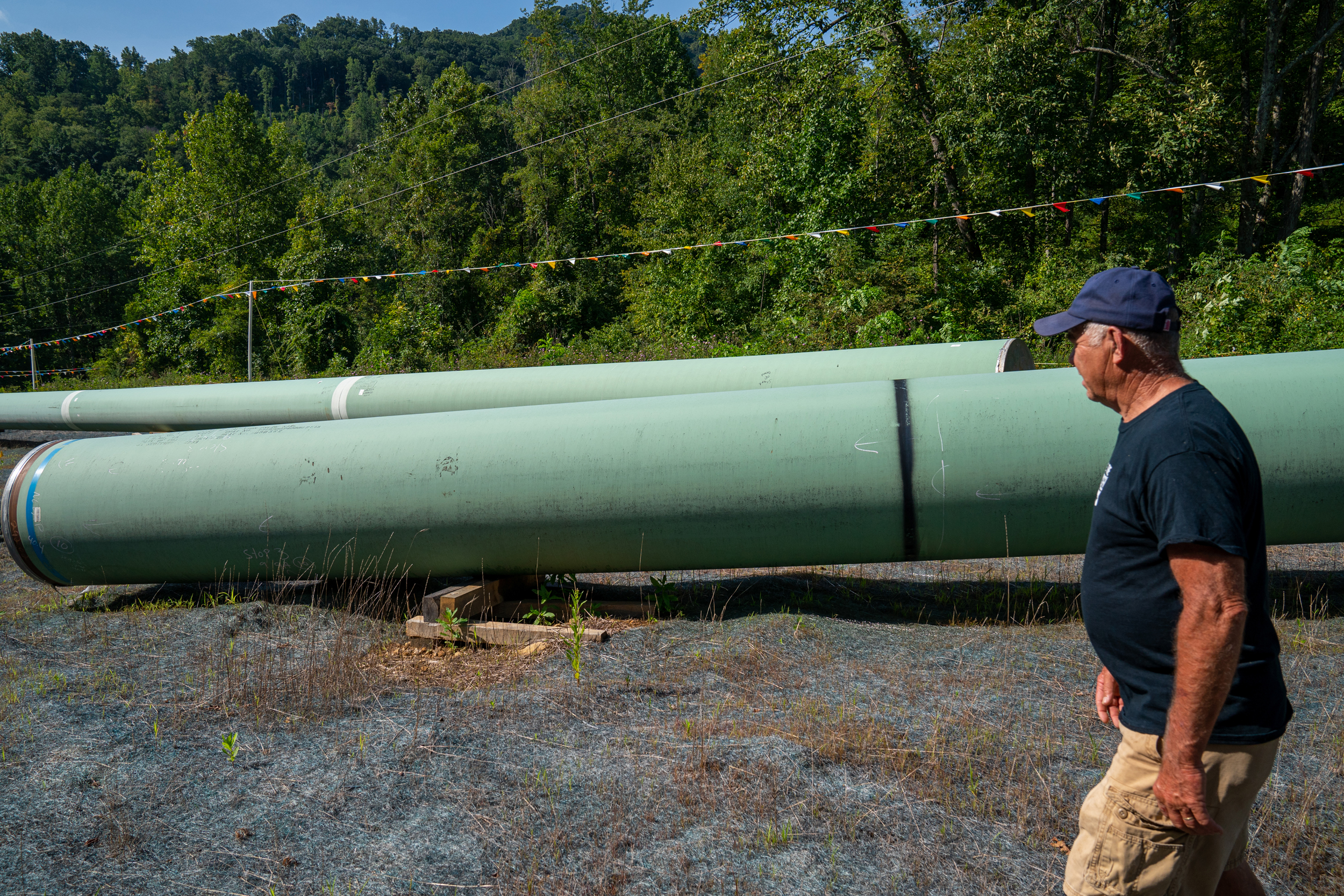 Local resident Bobby Amerson walks past sections of steel pipe to be used for the Mountain Valley Pipeline in Callaway, Va., on Aug. 30, 2022. Credit: Robert Nickelsberg/Getty Images