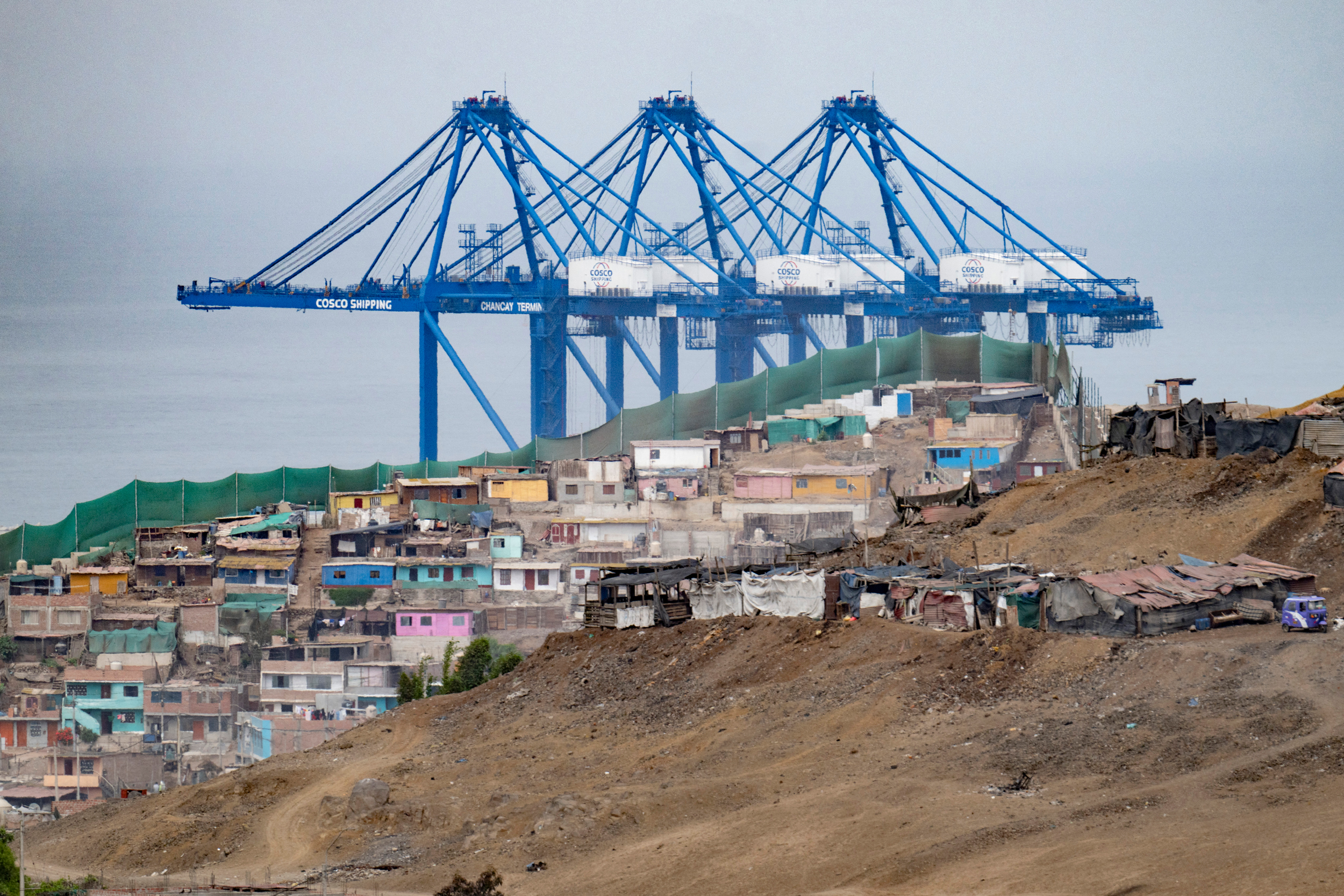 The cranes of a new megaport tower behind the town of Chancay, Peru. Credit: Cris Bouroncle/AFP via Getty Images