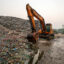 A cyclist passes a landfill, a known emitter of Methane, on Jan. 21 in Barisal, Bangladesh. Credit: Niamul Rifat/Anadolu via Getty Images
