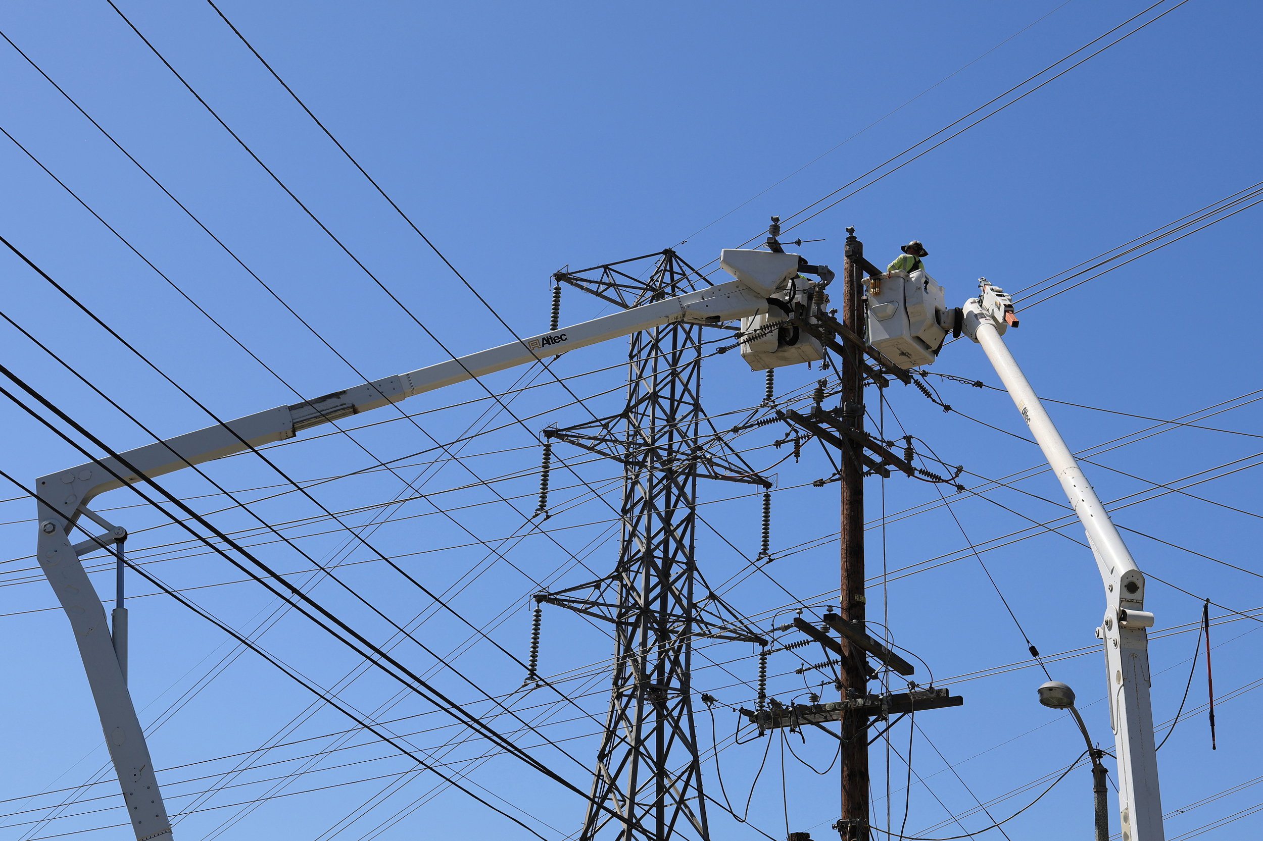 Workers repair transmission lines destroyed by the Eaton Fire on May 15 in Altadena, Calif. Credit: VCG via Getty Images