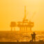 An oil platform looms in the distance off the coast of Huntington Beach, Calif., on Aug. 25. Credit: Leonard Ortiz/MediaNews Group/Orange County Register via Getty Images
